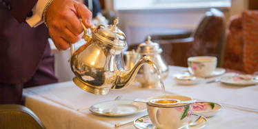 Tea being poured in elegant surroundings. An example of Afternoon Tea etiquette.